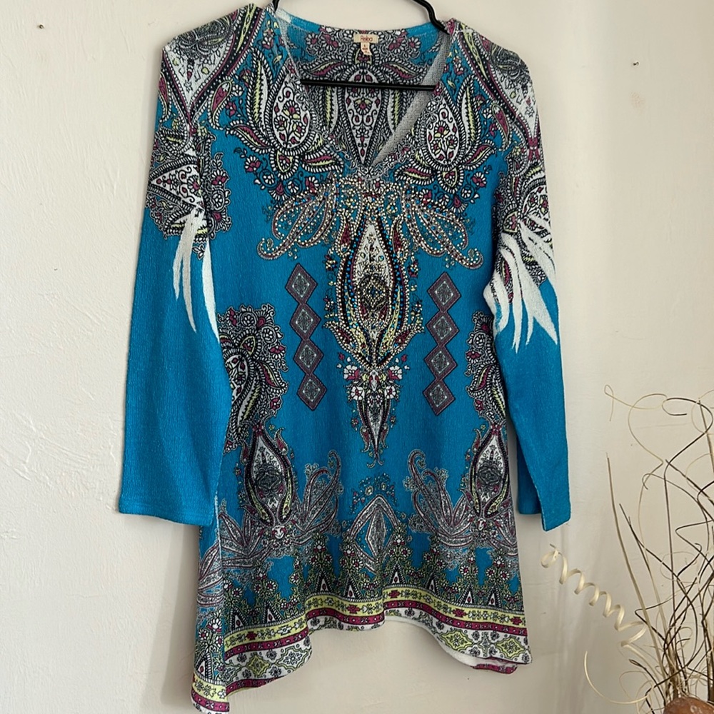 Reba bright blue top with multi color designs.